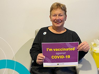 integratedliving CEO Catherine Daley holding a "I am vaccinated against COVID-19" sign