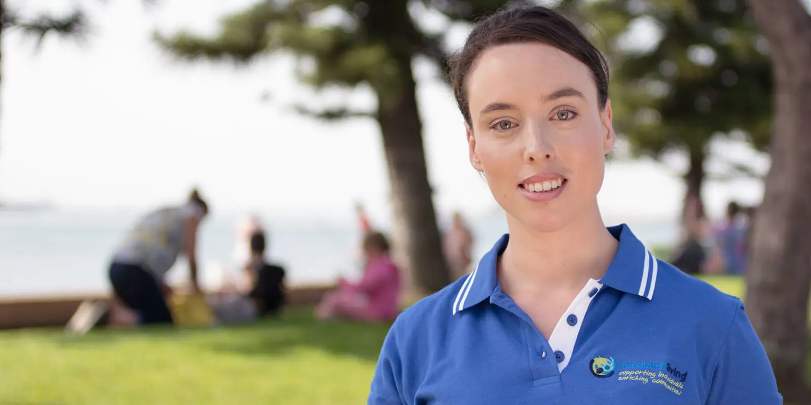 Image of an integratedliving staff with a background of a group of people doing exercise