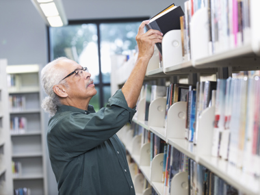 Man getting book from library shelf