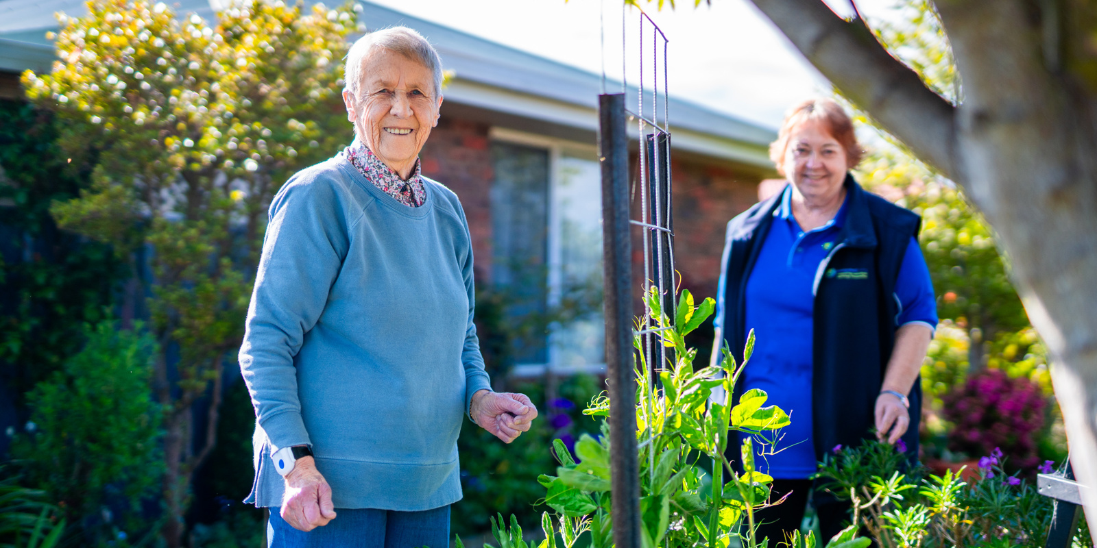 client and support worker in the garden smiling