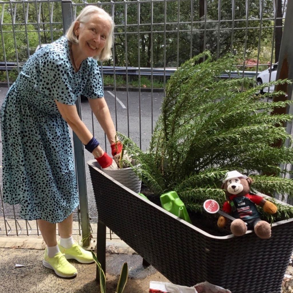 elderly lady gardening with planter box